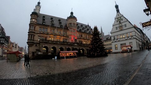 Rothenburg ob der Tauber, Germany, December 8, 2021: SLOW - The Market Square and Town Hall Tower, with its grand stairs, the Renaissance façade and surrounded by the romantic timber-frame buildings.