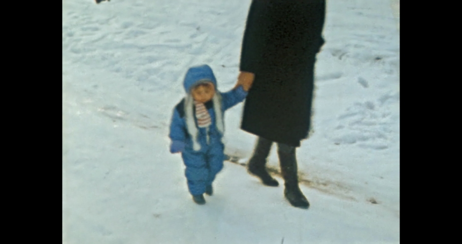 Happy family walk in winter park. White snow covered forest. Vacation in snowy nature. Mother holds child by hand. Spending time together. Vintage color film. Sentimental family archive. Retro 1980s