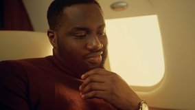 Guy using mobile phone in private jet closeup. Smiling bearded man hold in hands cellphone on corporate trip. African american checking social media. Happy passenger texting message chatting online. - Powered by Shutterstock - Get 15% off with code: PIKWIZARD15