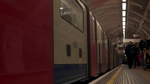 London, UK. July 20, 2021. Train on the platform with departure passengers at the Londons subway station. London tube 4k video.