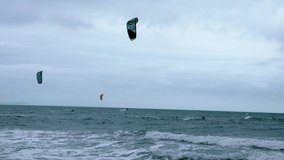 People kite boarding in the sea with huge waves. 4k video.