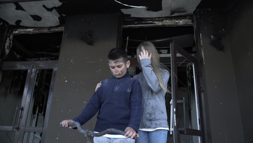 Boy and a girl are standing in their house after being hit by rockets, a little boy and a little girl are victims of the war