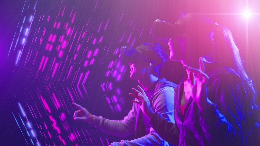 Metaverse digital world cyberspace futuristic technology, man and woman waring VR google virtual reality game playing neon futuristic background