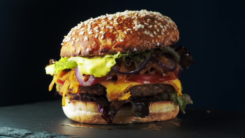 Vegan burger revolves on a slate plate. 4k Royalty-Free Stock Footage #1091405877