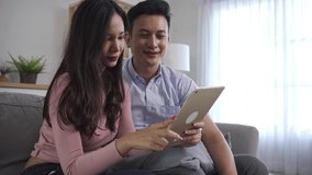 Asian couples watching or reading the news on tablets are shocked and delighted of the news they see. Couple were surprised by the news they had seen on the internet in couple and lifestyle concept