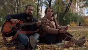 Young couple in love newlyweds sing romantic song talented composer musician playing guitar spend time together outdoors Fallen Leaves Look At Camera Cold Weather In Fall Park, Family, Autumn Concept - Powered by Shutterstock - Get 15% off with code: PIKWIZARD15