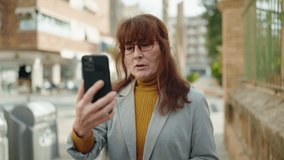 Middle age woman business executive having video call at street