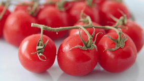 Close-up of a red organic cherry tomatoes on the blue plate. 3840x2160p footage.