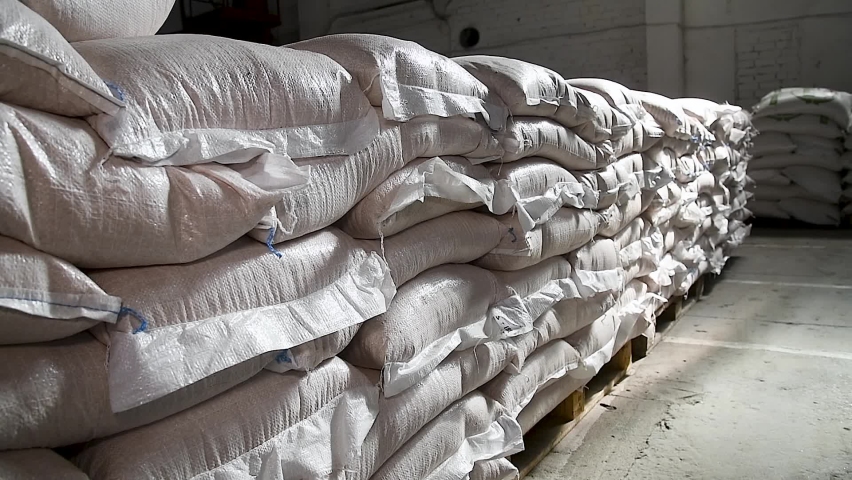 Food warehouse. Bags of rice, sugar, flour and other products. Warehouse filled with white heavy bags that lie on pallets Royalty-Free Stock Footage #1091418603