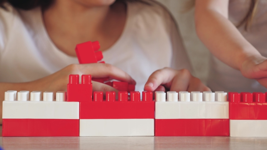 child play constructor with mother. red white colors. parent build together with kid from toy lego brick. teamwork. psychologist deals with child. happy family. group game constructor. chidhood dream Royalty-Free Stock Footage #1091422497