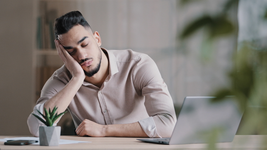 Tired sleepy hispanic man arab guy dreaming overworked male student slumber at office laying down on desk leisure close eyes napping feel exhausted falling asleep has chronic insomnia health problem Royalty-Free Stock Footage #1091426299