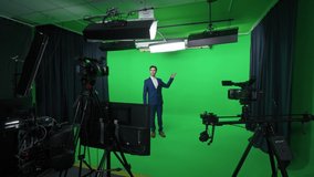 Behind the scenes, news anchor at work, man reporter looks into the camera and talks, studio TV news shooting, chroma key template.