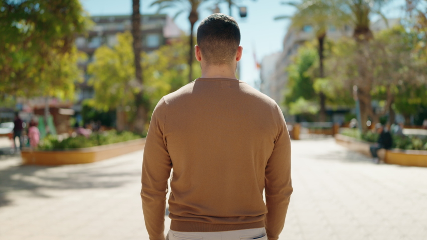 Young hispanic man smiling confident standing with arms crossed gesture at park