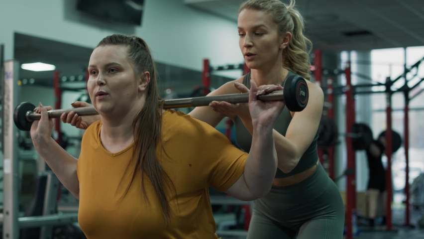 Caucasian woman with overweight doing training with fitness instructor at the gym. Shot with RED helium camera in 4K.   Royalty-Free Stock Footage #1091433613