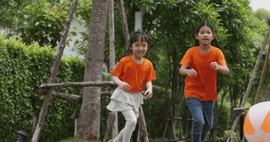 4K video slow motion Asian children wear orange t-shirt play in playground. Concept for funny and active activity of kid.