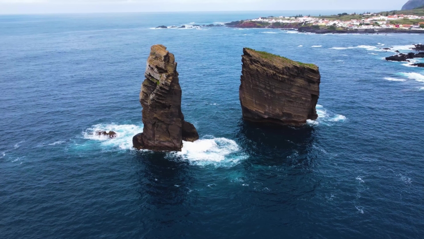 Sao Miguell island, Azores, Portugal. Aerial view on lonely lava rocks separated from the coast. Orbit shot of rocky coastline in Azores in Portugal. Royalty-Free Stock Footage #1091434979