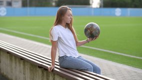 Happy attractive woman sitting on bench near soccer field with soccer ball in hands and playing. urban lifestyle - Powered by Shutterstock - Get 15% off with code: PIKWIZARD15