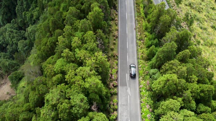 Top view of a car driving along a curved road. Aerial view of mountain road near Lagoa das Sete Cidades and Santiago Lake Royalty-Free Stock Footage #1091440213