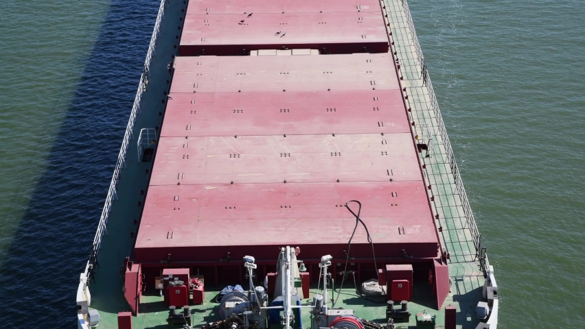 Aerial close-up view of red deck and hull of large general cargo ship sailing on water. Global business. No people. Full HD real time video. Shipping theme. | Shutterstock HD Video #1091443937