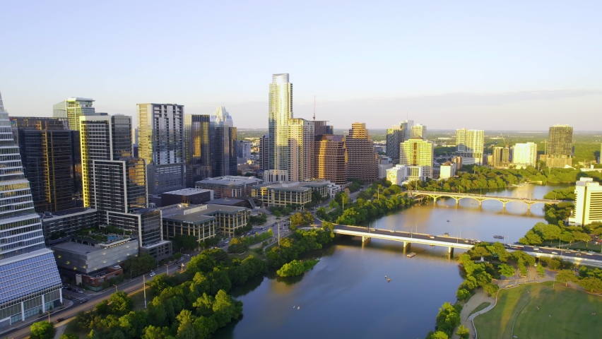 Aerial view of the riverside cityscape of sunny Austin, USA - tracking, drone shot