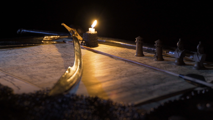 Medieval historical sword. Accompanied by war map and candle.
Plan making on the medieval sword and war map.
