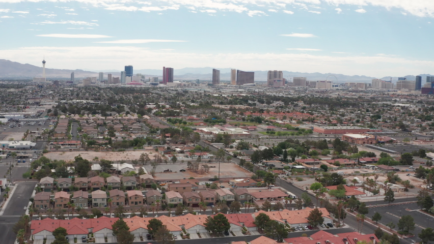 Aerial pullback shot of Las Vegas residential houses with city skyline view