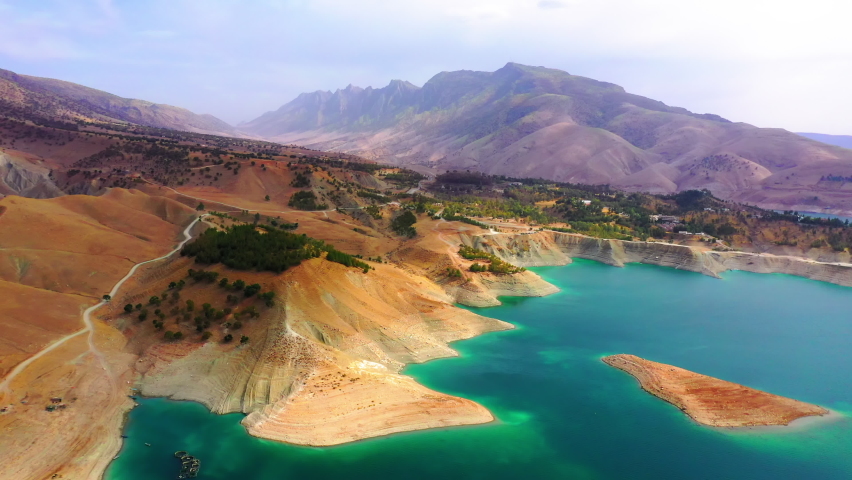 Aerial Forward Scenic Shot Of Natural Mountains By Green Coastline Of Lake - Kurdistan, Iraq Royalty-Free Stock Footage #1091464099