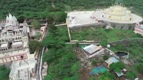Palitana , Gujarat , India - 06 14 2022: Aerial shot of Palitana temple and dense forest . The Palitana temples of Jainism are located on Shatrunjaya hill by the city of Palitana in Bhavnagar district