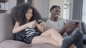 Father and daughter having fun playing console games on vacation day. Daughter is very happy after winning. Holiday family activities concept.