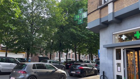 Brussels, Belgium - June 15, 2022; Cars parked next to a pharmacy in Bruxelles