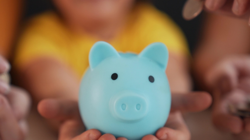 Close-up of hand throwing coins into piggy bank. Financial and business safety. Coins in piggy bank symbol of bank safety. Financial savings are kept in bank. Business and financial safety concept Royalty-Free Stock Footage #1091475699