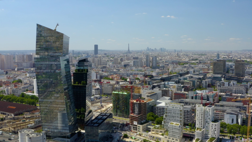 France, Paris suburb. Eiffel tower and La Défense in the background. Forward drone aerial view. Aerial drone shot of the Cityscape of Paris, France. 