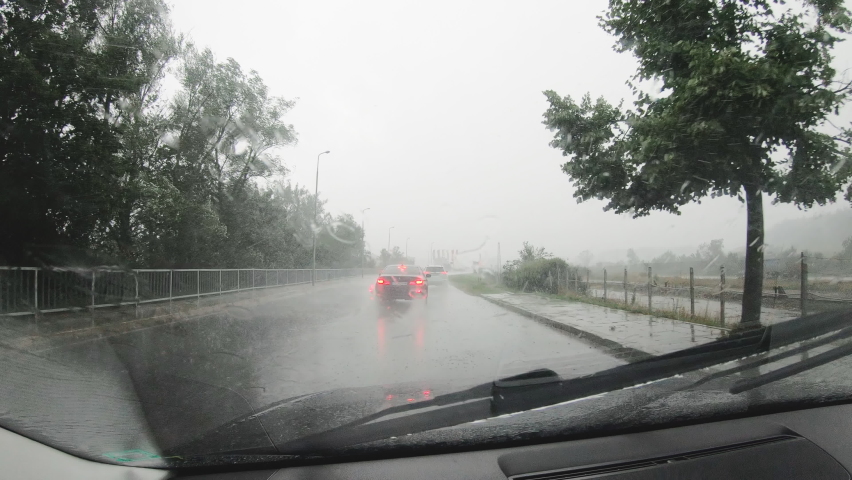 Close-up raindrops from the windshield,Dark cloud, an heavy raining. The road are wet. To be safe, slowly and carefully on driving.