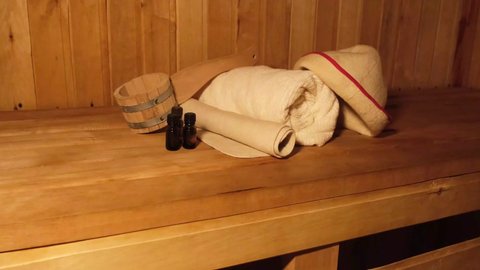 Traditional old Russian bathhouse SPA Concept. Interior details Finnish sauna steam room with traditional sauna accessories set basin towel aroma oil scoop felt. Relax country village bath concept
