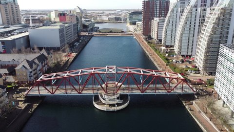 Salford Quays England. June 2, 2022. Aerial footage looking down onto a river surrounded by modern buildings  and a pedestrian bridge. Incredible modern architecture. 