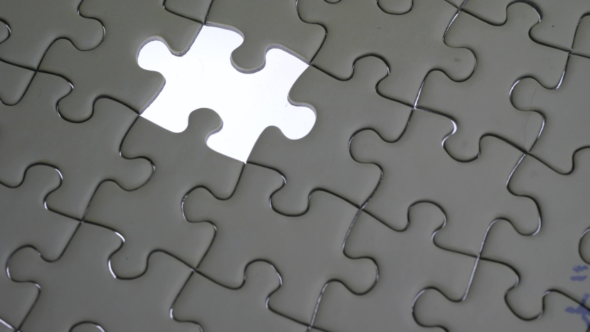 Hand holding jigsaw puzzle last missing piece lighting. 
Concept last piece of jigsaw puzzle for problem and 
completion.