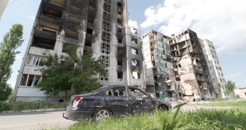 Borodyanka - town in Kyiv Oblast, Ukraine. Crushed shot car is staying near destroyed bilding. Burnt apartments. The consequences of the bombing of Ukrainian cities