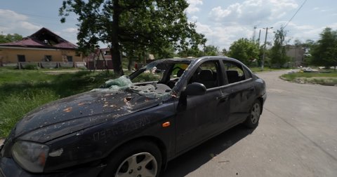 Borodyanka, Kyiv Oblast, Ukraine - summer 2022. Crushed shot car is staying near destroyed bilding. Burnt apartments. The consequences of the bombing of Ukrainian cities