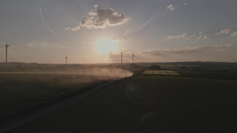 Kehrig , Eifel , Germany - 06 06 2022: Agricultural Farming with Renewable Energy Wind Turbines at Sunset.