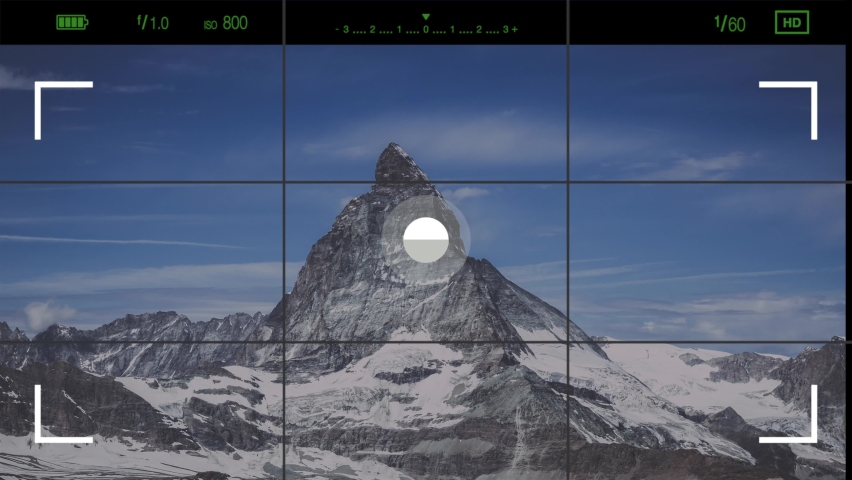 A look through photo camera at Matterhorn mountain in national park of Zermatt, Switzerland. Summer landscape with clear blue sky and sunshine weather