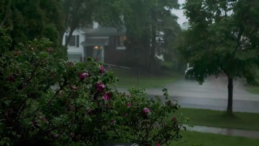 Close up view Heavy rain, with loud thunder and lightning, a suburban residential street. Slow motion footage
