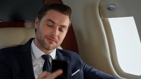 Manager finishing phone call on jet closeup. Confident man look airplane window. Thinking handsome businessman speaking partner on business trip. Successful man work have mobile conversation in suit. - Powered by Shutterstock - Get 15% off with code: PIKWIZARD15