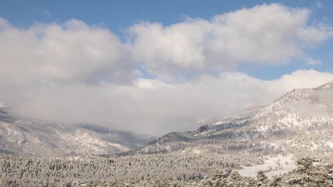 Time Lapse of the clouds moving above the snow covered mountains in the Rocky Mountains National Park in Colorado USA.