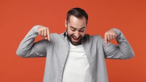 Promoter excited young brunet man 20s years old wears blue shirt pointing fingers hands down on workspace copy space mockup promo commercial area isolated on plain orange background studio portrait - Powered by Shutterstock - Get 15% off with code: PIKWIZARD15