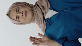 Sad young woman in hijab is afraid.Woman posing in studio portrait isolated on white background. Portrait showing sad gesture in face of surprise.Video for the vertical story.