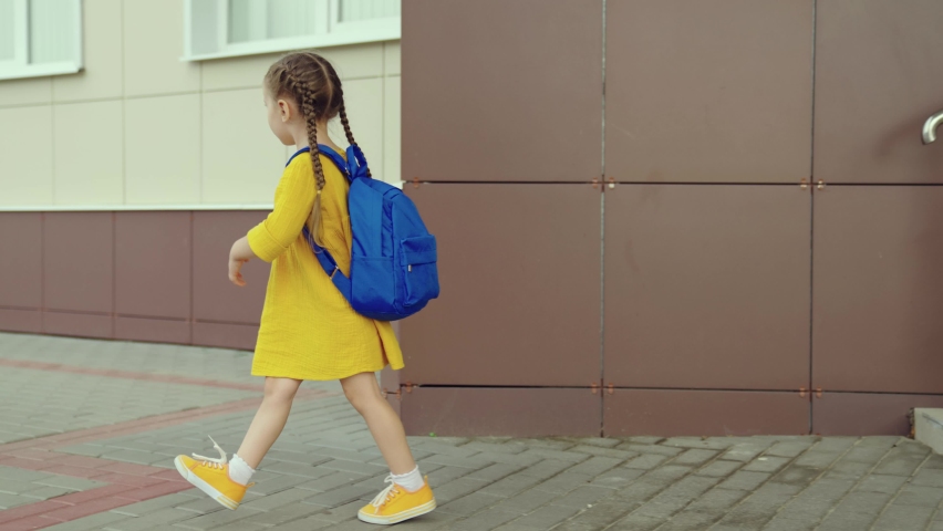 Child goes to school, education. Little schoolgirl daughter with backpack enters school building. Future belongs to children. Little girl with backpack goes to school. Children education concept. | Shutterstock HD Video #1091501037