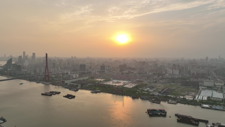 Drone aerial view of City in dusk, massive of building in the sunset. Huangpu river, downtown area Shanghai China. All in orange sky. Business, travel and life style concept b-roll footage.