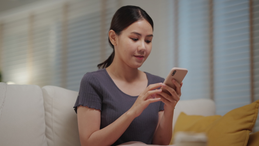 Asia people single woman sit at home sofa couch read and look at man boy photo post on phone. Relax smile choose lover enjoy play right swipe on tinder app to find love couple in fun match flirt chat. Royalty-Free Stock Footage #1091502875