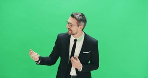 Businessmen can rock it out too. 4k video footage of a businessman pretending to play guitar against a green background.