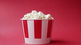 childrens Caucasian hand taking popcorn from striped red and white paper box